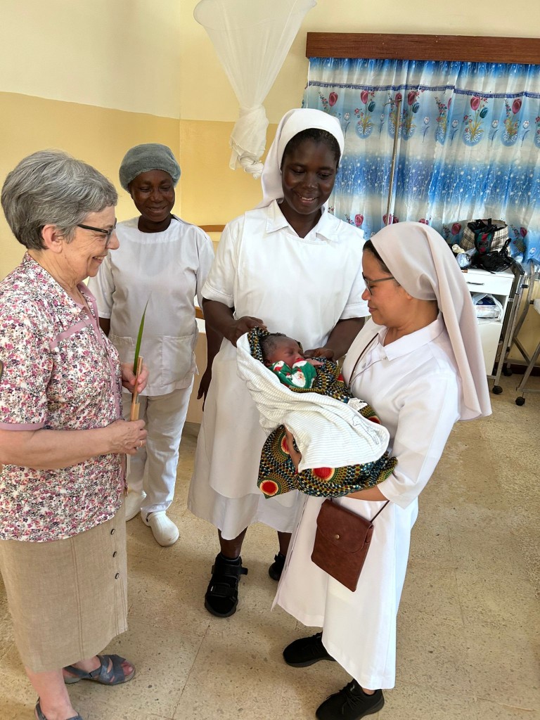 Sisters Hospitallers visiting the maternal and child health service in Monrovia, holding a newborn baby.