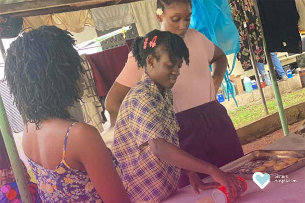 Women preparing food together in a community activity supported by Sisters Hospitallers