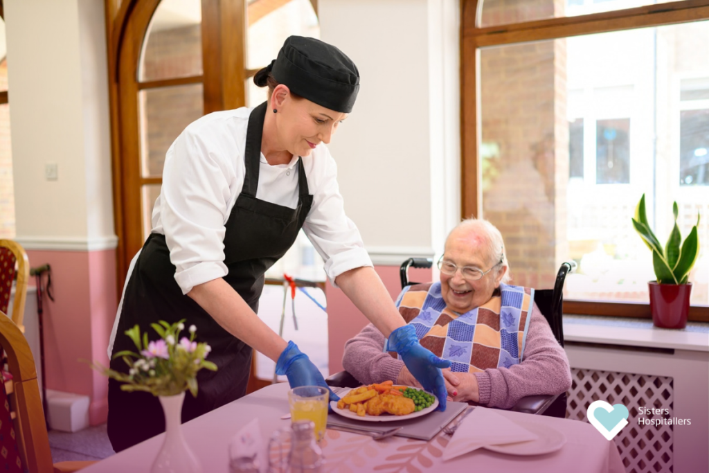 Care worker serving a meal to an elderly resident in a moment of attentive care