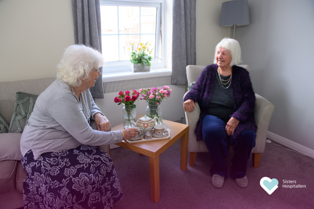 Two elderly women sharing a conversation in a care community