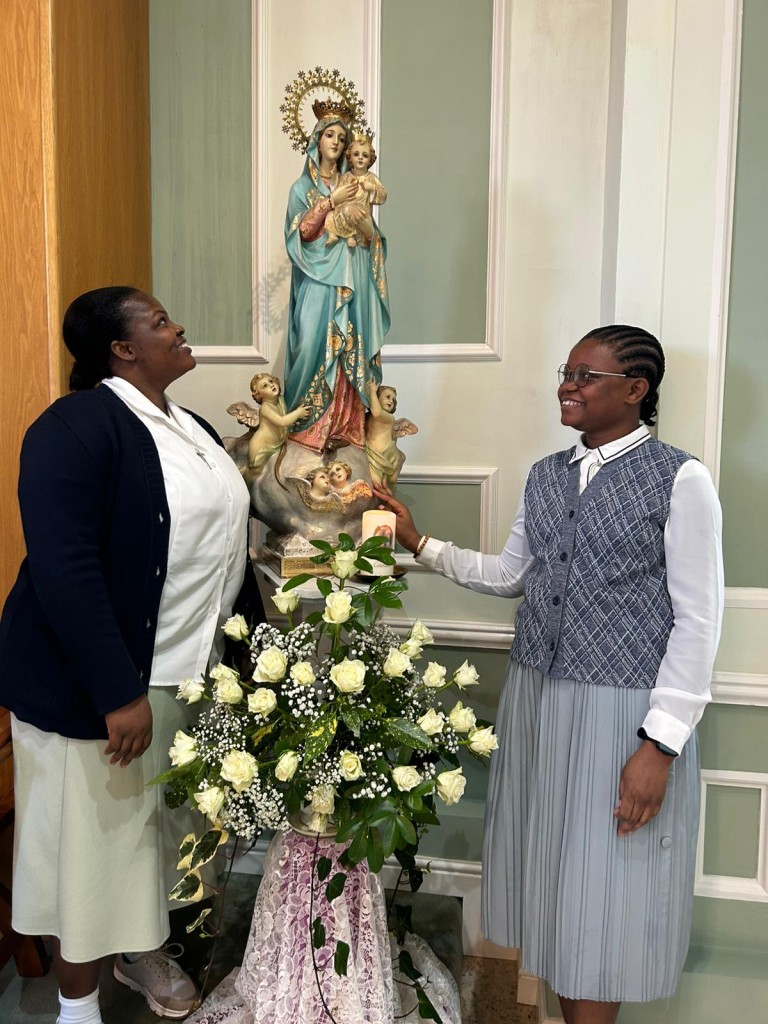 Sisters Hospitallers next to statue of Our Lady during Annunciation celebration at Footherley Hall Shenstone