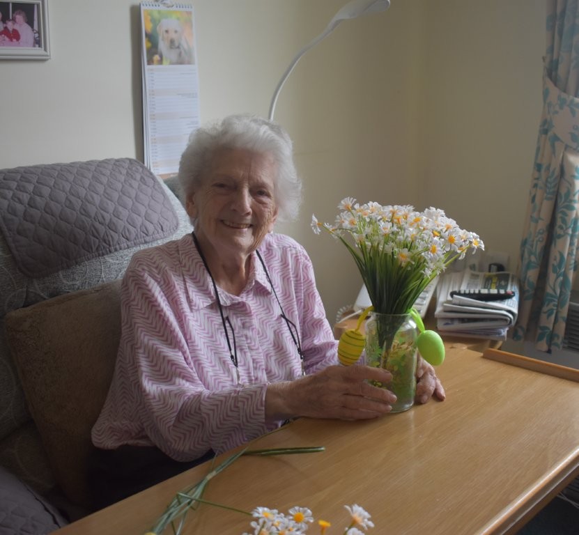 Resident holding a finished flower arrangement at Footherley Hall