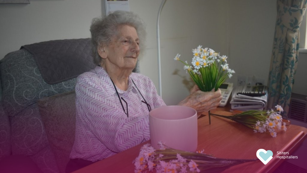 Resident arranging flowers during a creative activity at Footherley Hall care home