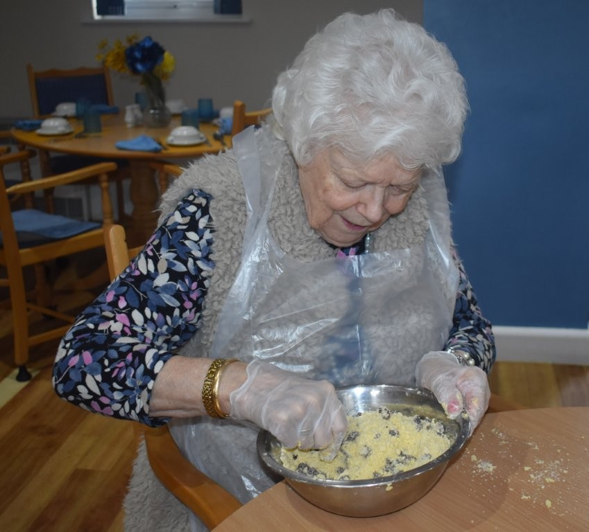 Resident baking during a group baking activity at Footherley Hall