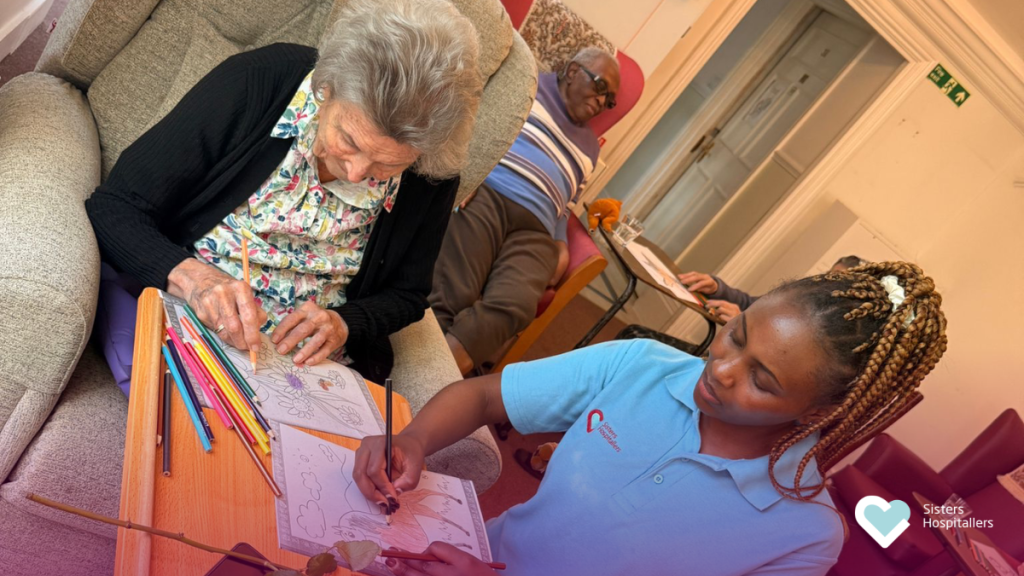 Resident and staff member colouring together during an activity session at St Teresa’s care home
