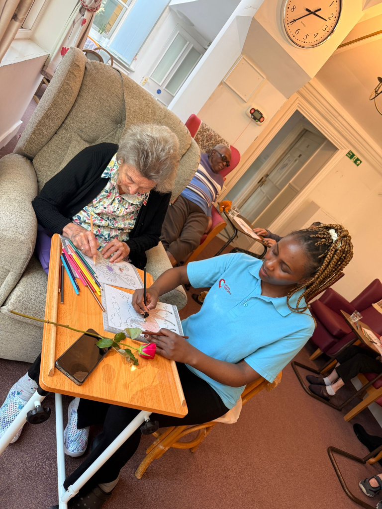 Resident and staff member colouring together during an activity session at St Teresa’s care home