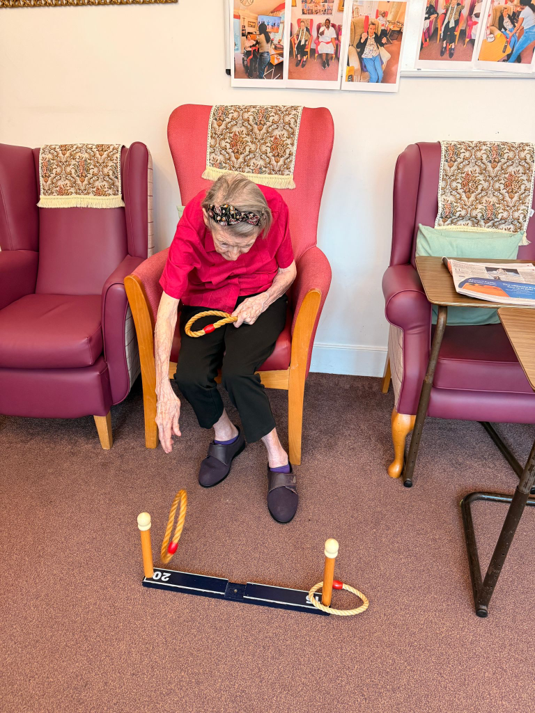Resident playing a ring toss game to support coordination and movement at St Teresa’s