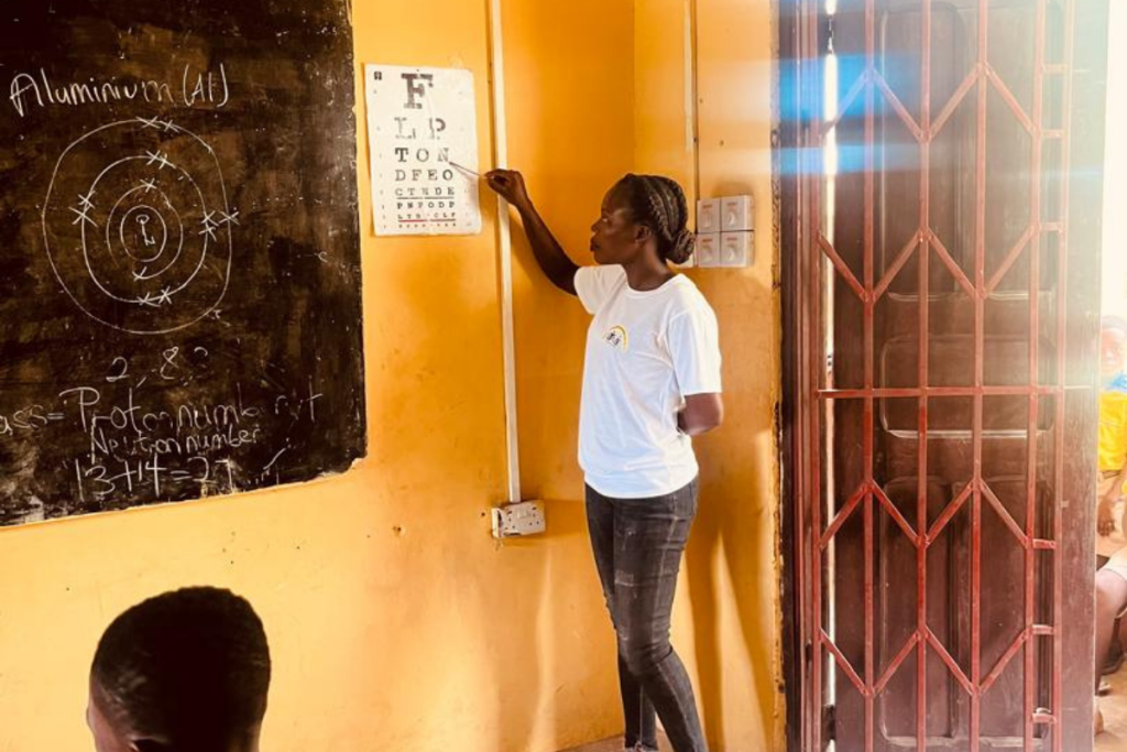 Health worker conducting screening test for student during outreach activity in Foso Ghana