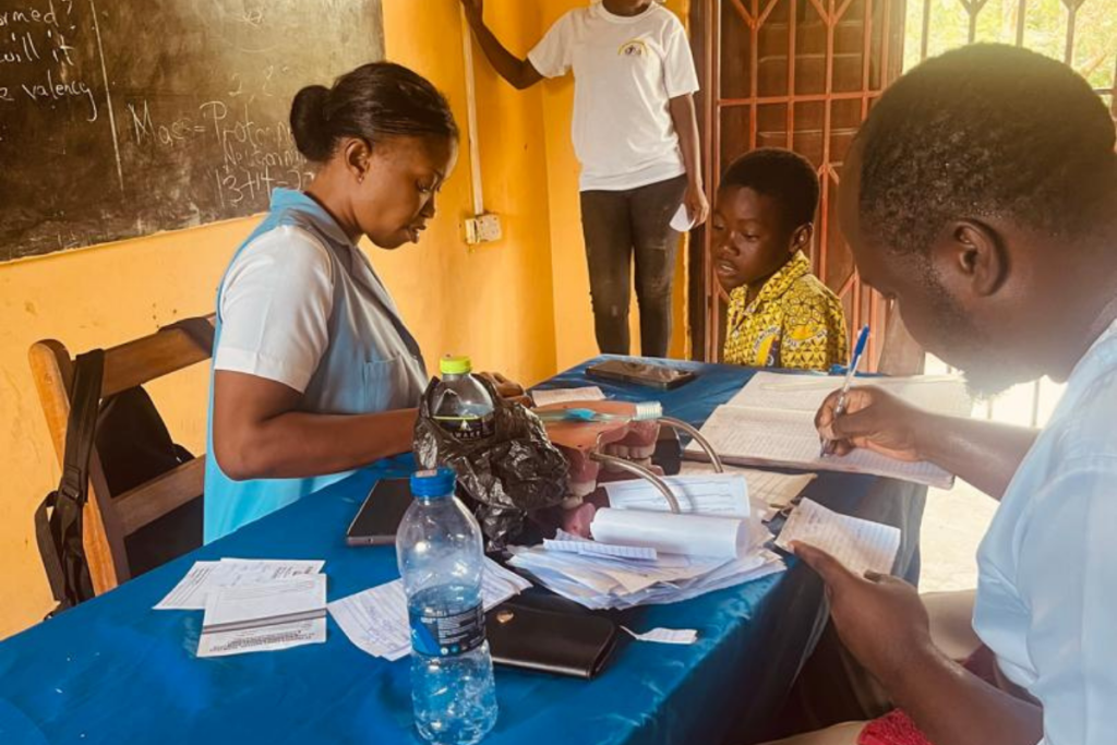 Healthcare staff recording information during school outreach in Foso Ghana