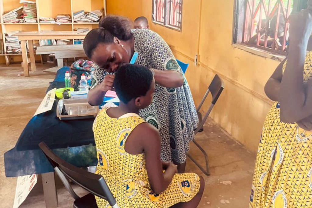 Healthcare worker checking child oral health during World Oral Health Day outreach in Foso Ghana